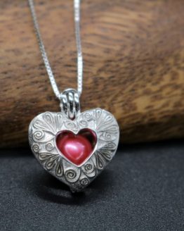 sterling silver heart locket that holds a pearl