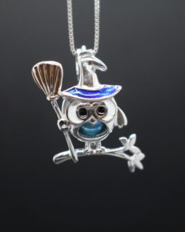 sterling silver owl dressed as a witch perched on a branch holding a broomstick locket that holds pearl.
